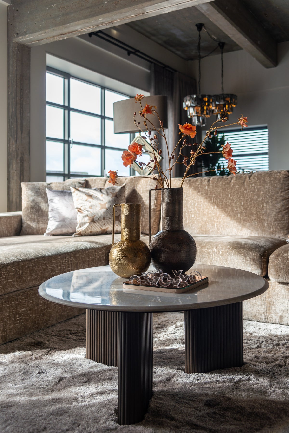 Salontafel Mayfield bruin mangohout wit marmer, schuin vooraanzicht in een interieur