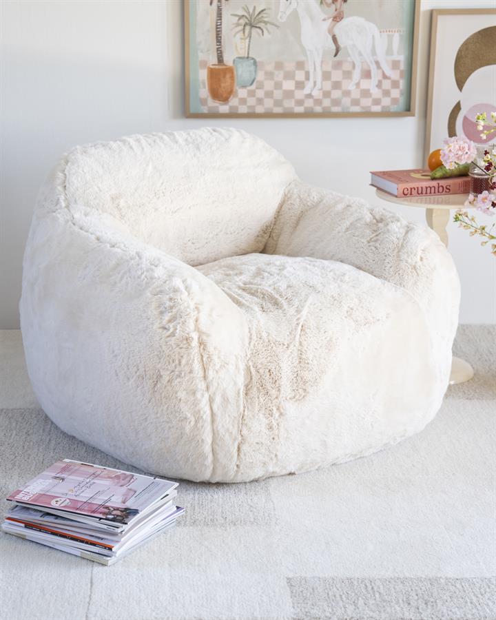 Fauteuil Hug beige polyester, schuin vooraanzicht in een interieur