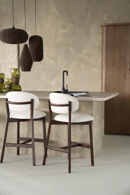 Barkruk Mikky beige stof bruin eikenhout in een interieur
