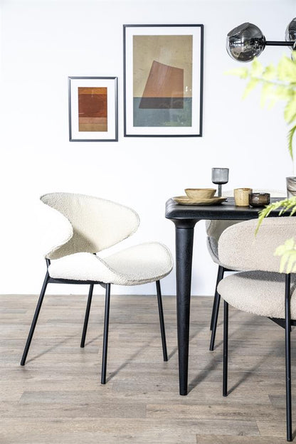 Eetkamerstoel Tess beige stof met armleuning, schuin vooraanzicht in een interieur