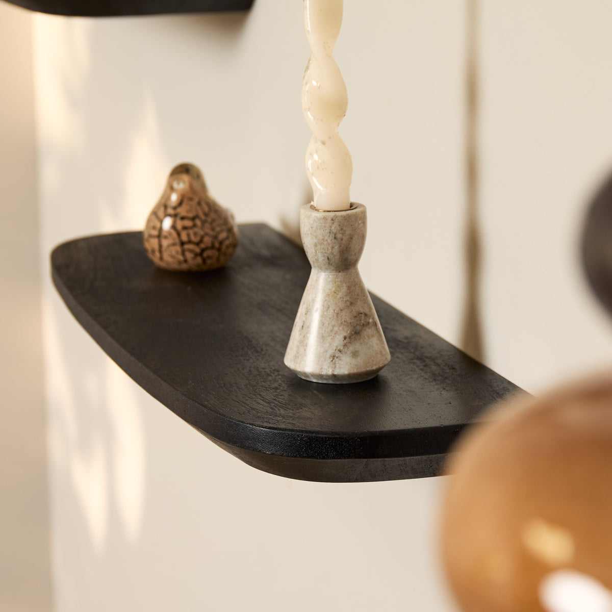 Wandplank Gusta zwart mangohout, schuin vooraanzicht in een interieur