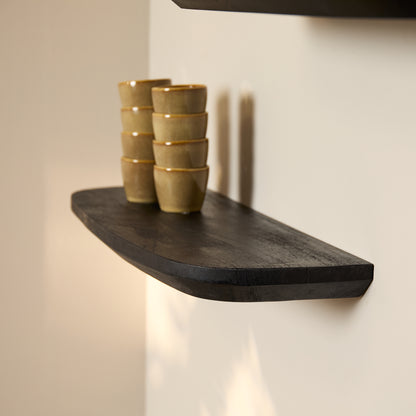 Wandplank Gusta zwart mangohout, schuin vooraanzicht in een interieur