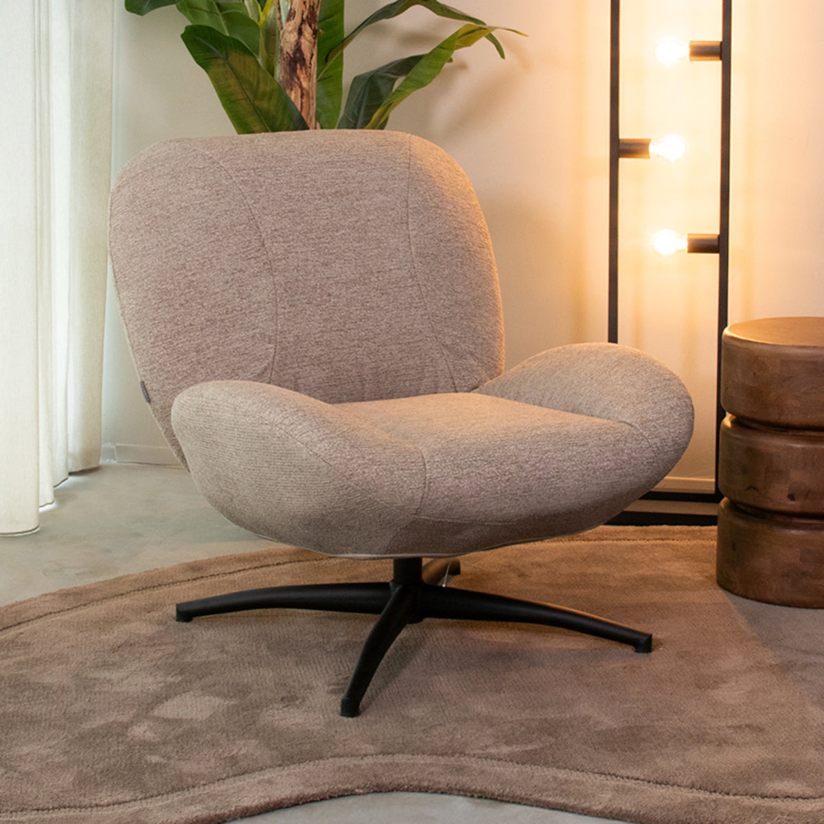 Fauteuil Clayton taupe stof, schuin vooraanzicht in een interieur
