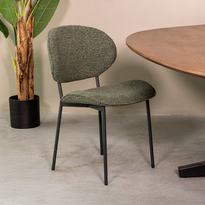 Eetkamerstoel Senn groen bouclé, schuin vooraanzicht in een interieur