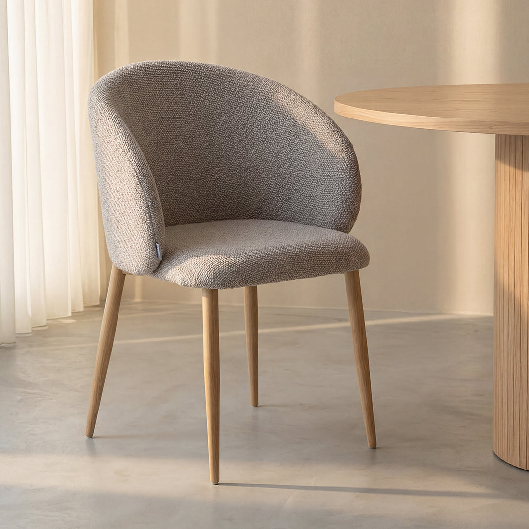 Eetkamerstoel Yuki naturel bouclé naturel metaal, schuin vooraanzicht in een interieur