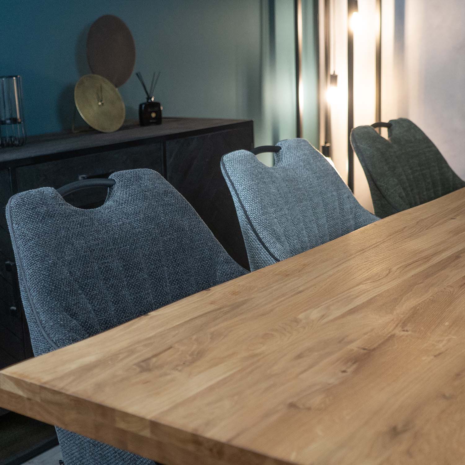 stoffen eetkamerstoelen bij meubelbaas aan eikenhouten eettafel