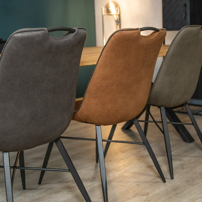 verschillende kleuren trofee stoelen aan industriële eettafel